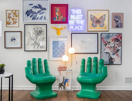 Green accent chairs with eclectic gallery wall and neon sign
